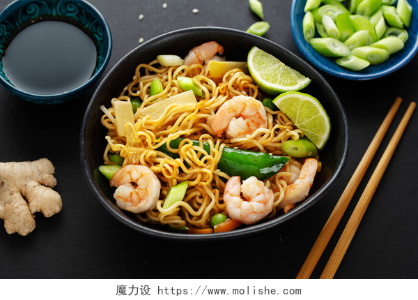 在盘子里的蔬菜炒虾仁烩面带着蔬菜和虾仁的亚洲面在深色背景下吃起来很好吃.